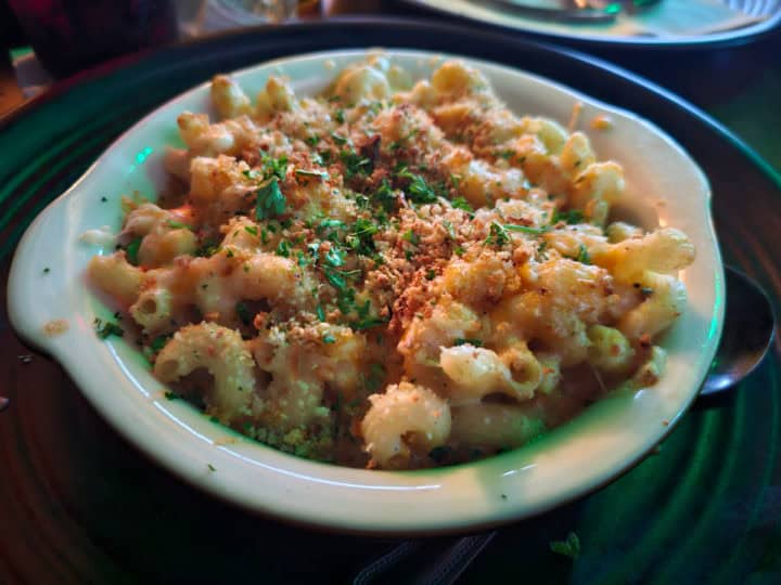 Guinness Mac and Cheese in a white bowl topped with bread crumbs and green garnish