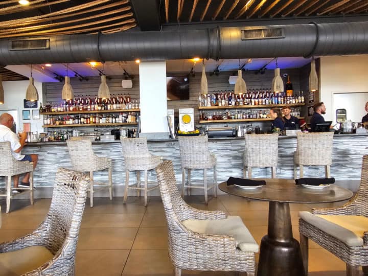 looking over tables to an indoor bar with staff behind the counter