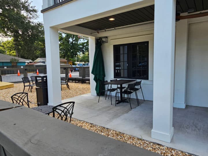 outdoor tables and chairs next to a white building