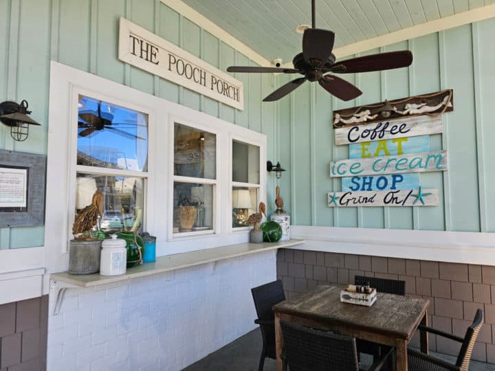 The Pooch Porch sign over an outdoor table and chairs below a fan at The Southern Grind