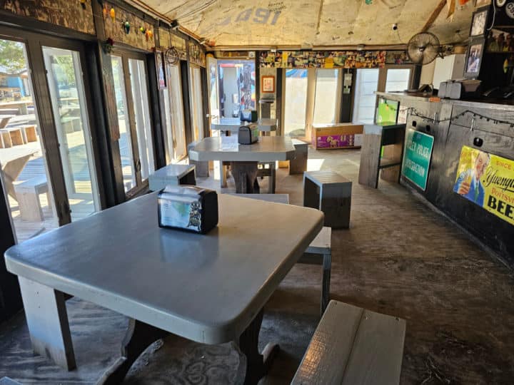 indoor tables and chairs next to a wooden bar