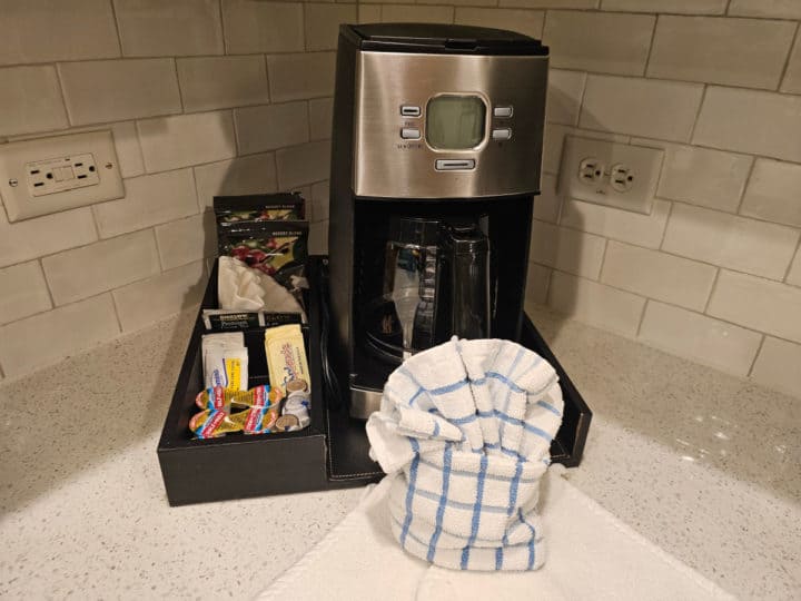 coffee maker with coffee and creamer set up, dish towel