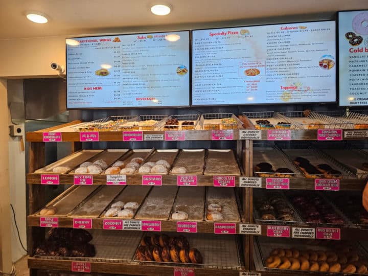 donut displays in long baskets below a menu board