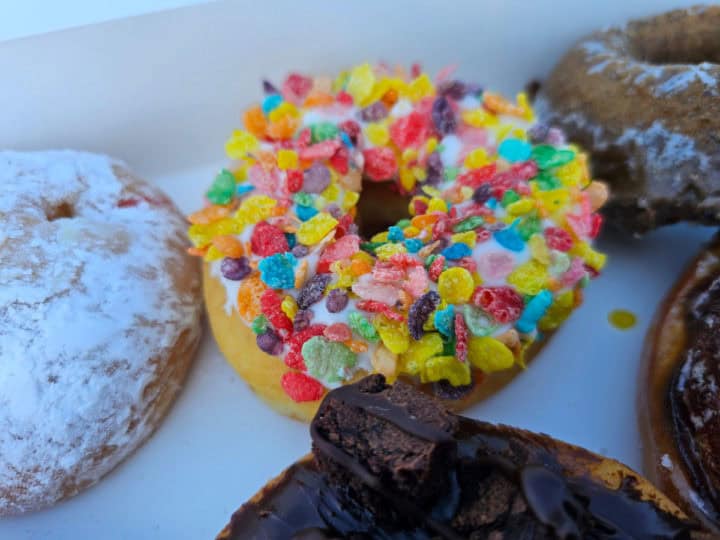 Fruity pebbles topped donut in a white box