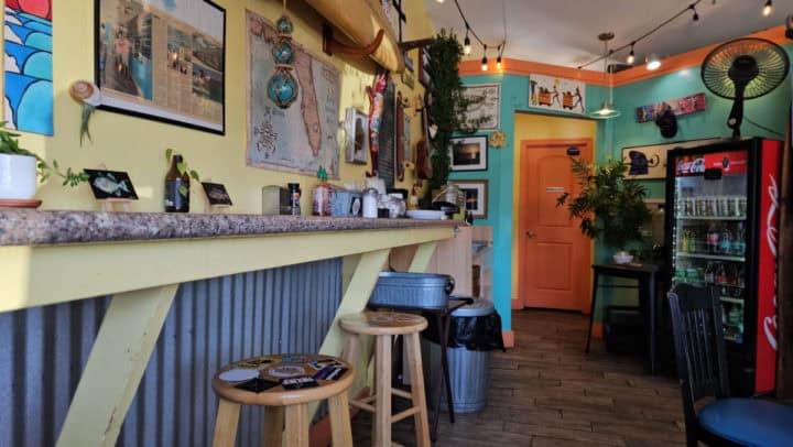 counter seating with surf photos and plants on the wall