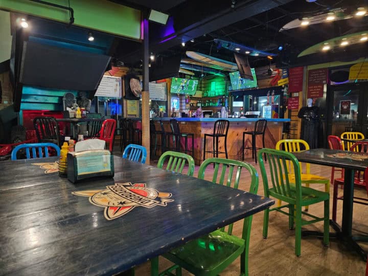 indoor tables with multi colored chairs and a bar in the corner