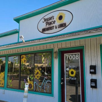 Jesse's Place breakfast and lunch sign over restaurant entrance, sunflowers painted on the windows