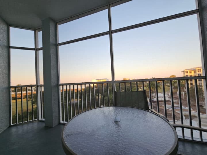 screened in deck with table and chairs looking out towards sunrise