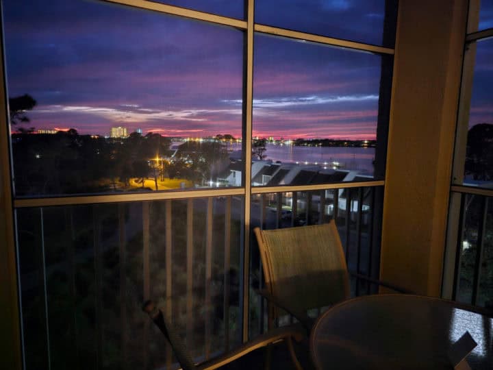 purple and pink sunset clouds from a screened in porch