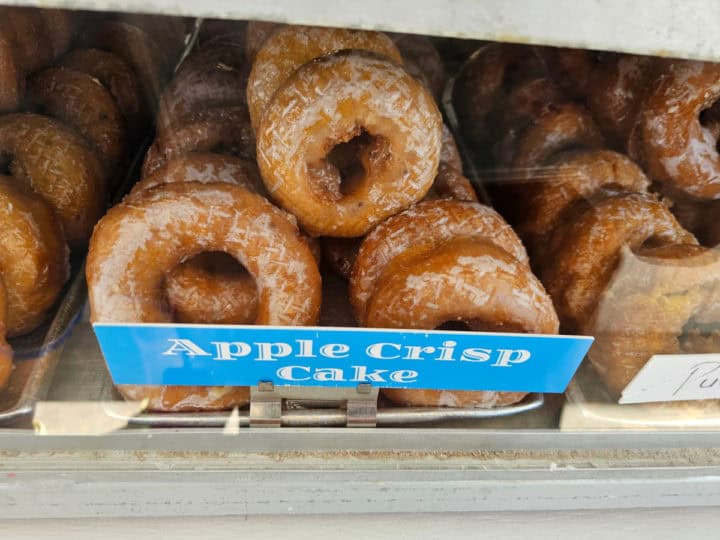 Apple crisp cake donuts on a silver platter with blue sign