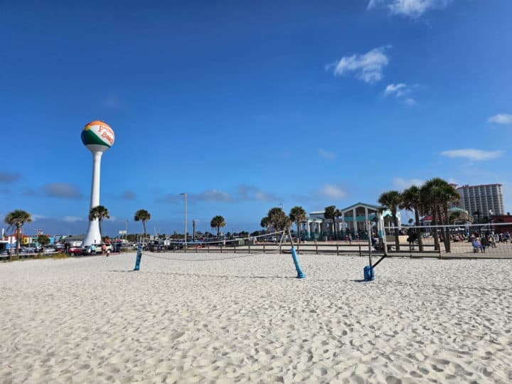 beach volleyball nets set up on the sand near the Pensacola beach ball water tower