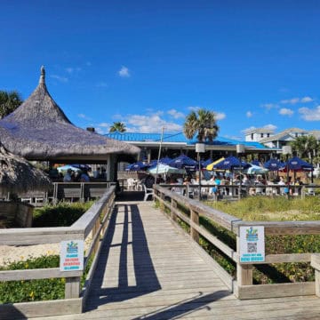 boardwalk ramp leading up to the Blue Parrot Cafe with tiki hut bar and outdoor seating