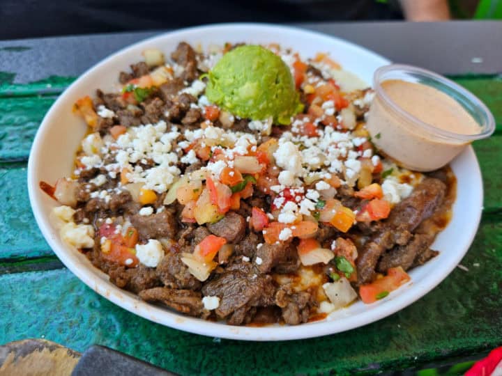 carne asada bowl with sauce in a white bowl