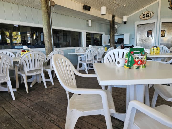 covered outdoor seating with white plastic chairs and tables