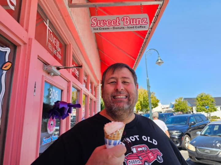 John holding an ice cream cone under the Sweet Bunz sign