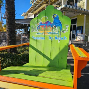 Large green Adirondack chair with Jimmy Buffets Margaritavilla Panama City beach printed on it