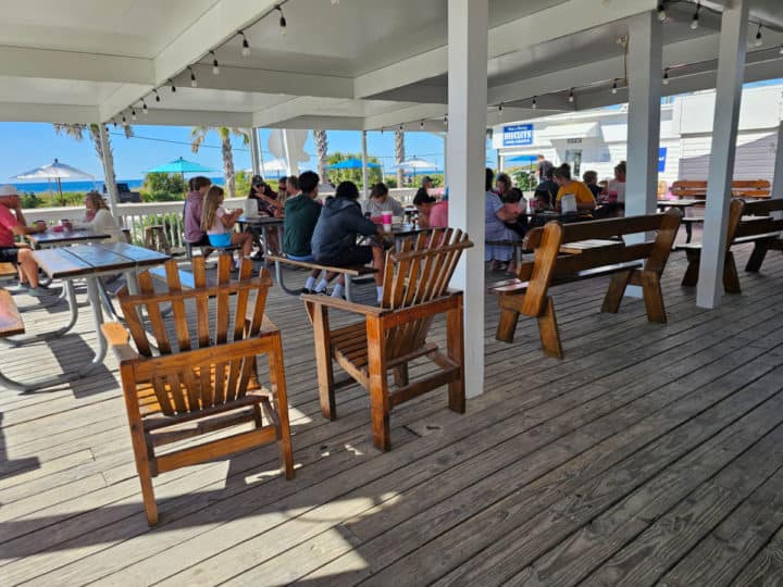 outdoor covered deck seating with picnic tables and tall Adirondack chairs