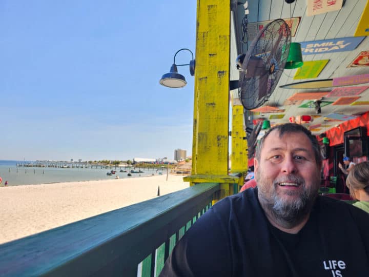 John sitting on the back deck with the beach 