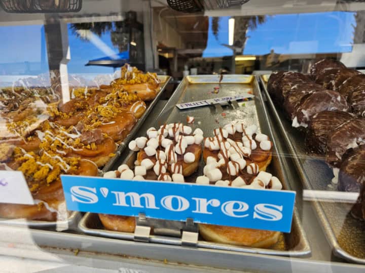 Smores donuts on a silver platter in a display case