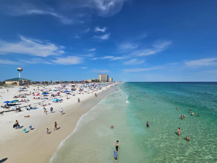 looking down Casino Beach with people on the white sand and in the water