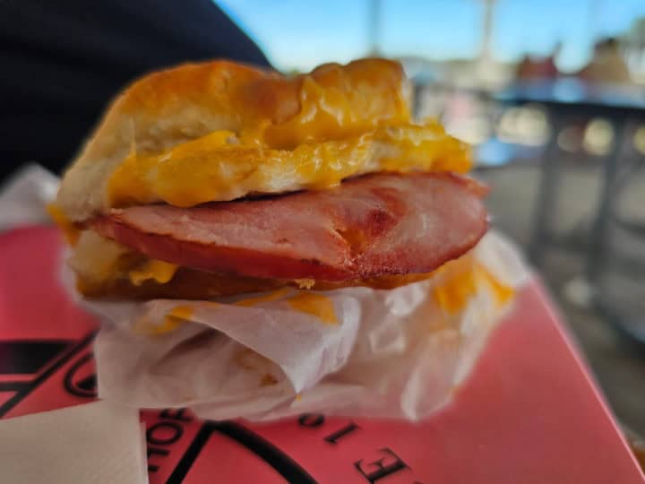 ham and cheese biscuit sitting on a pink Thomas donuts box