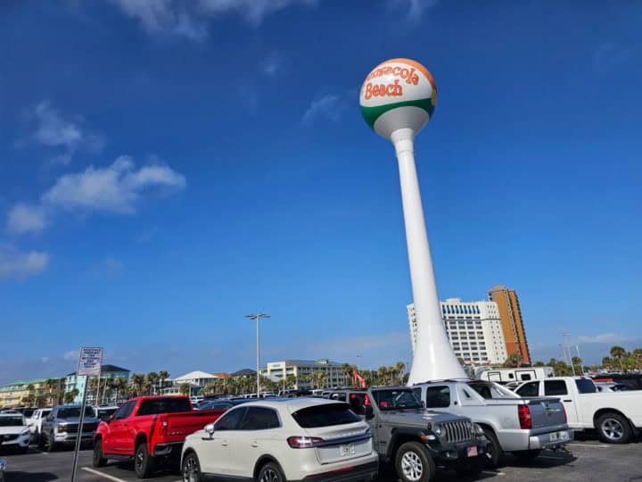 Pensacola beach ball water tower over cars in the parking lot