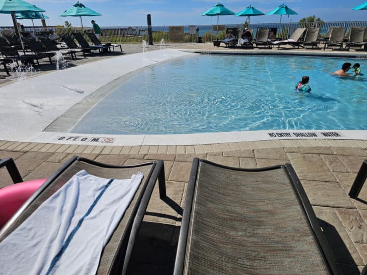 gradual entry into the pool with people in the water. lawn chairs on the deck