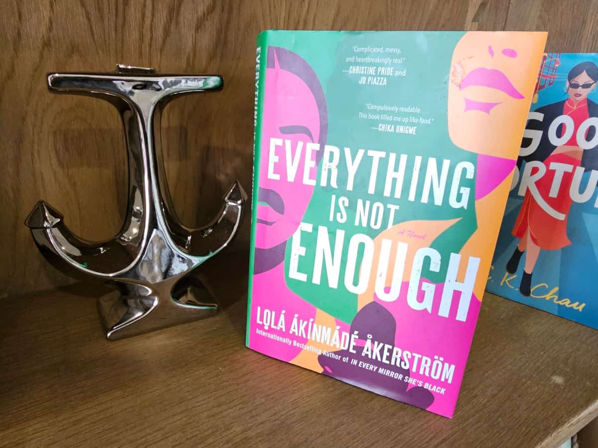 Everything is not enough by Lola Akinmade Akerstrom book next to a silver anchor