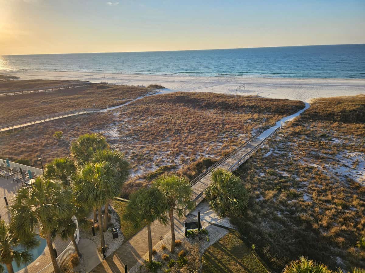 Looking down over walkways through sand dunes leading out to the white sand beach and Gulf of Mexico