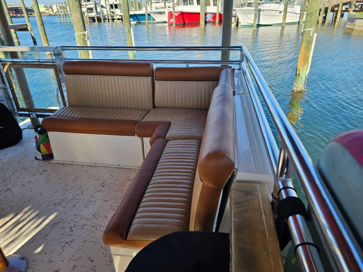 wrap around brown leather couch on the pink pearl tiki boat