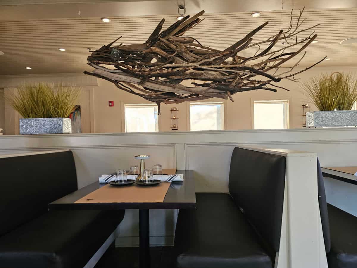 fish made out of driftwood above booths with dark leather seats