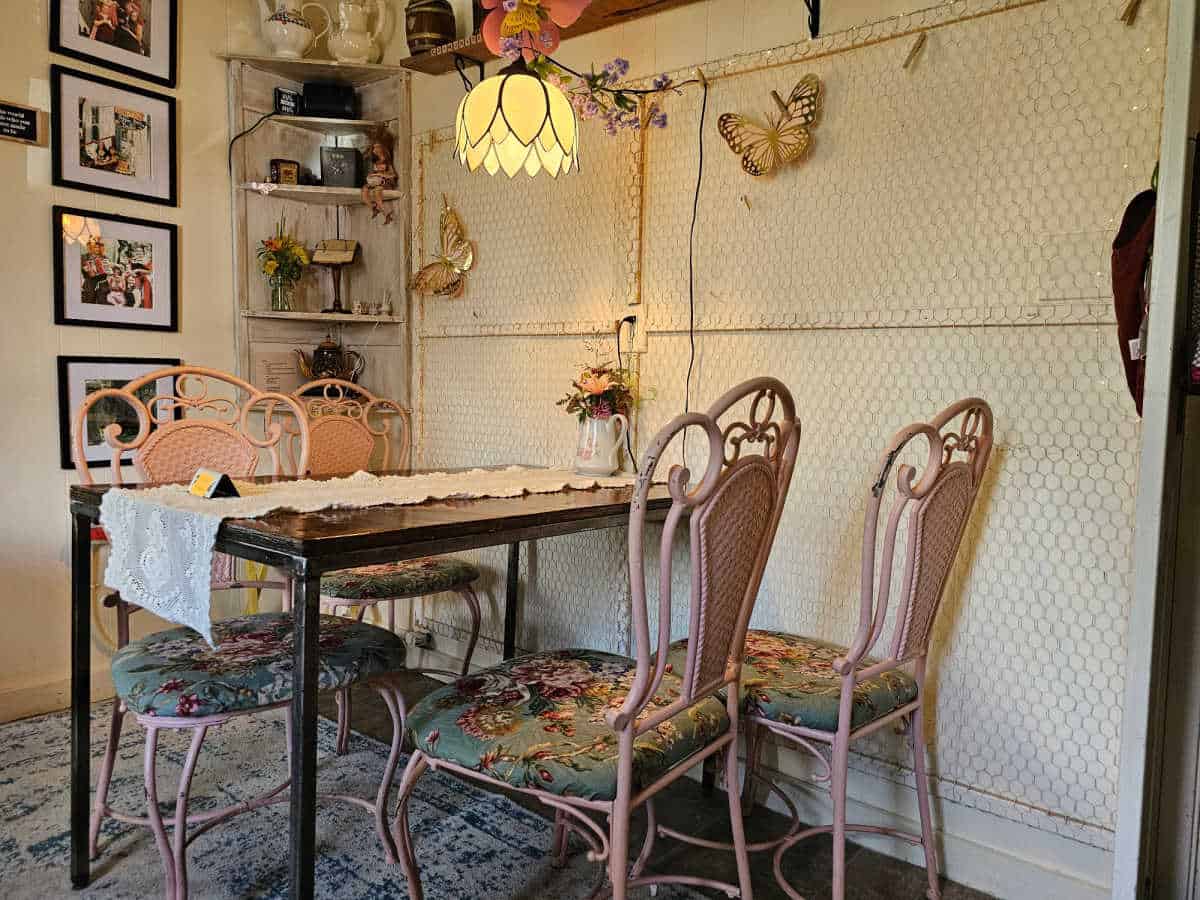 indoor seating wtih ornate chairs, and flower lamp, photos on the wall