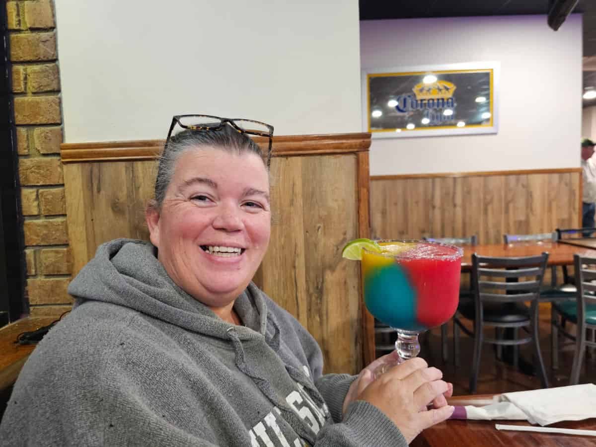 Tammilee holding a rainbow margarita