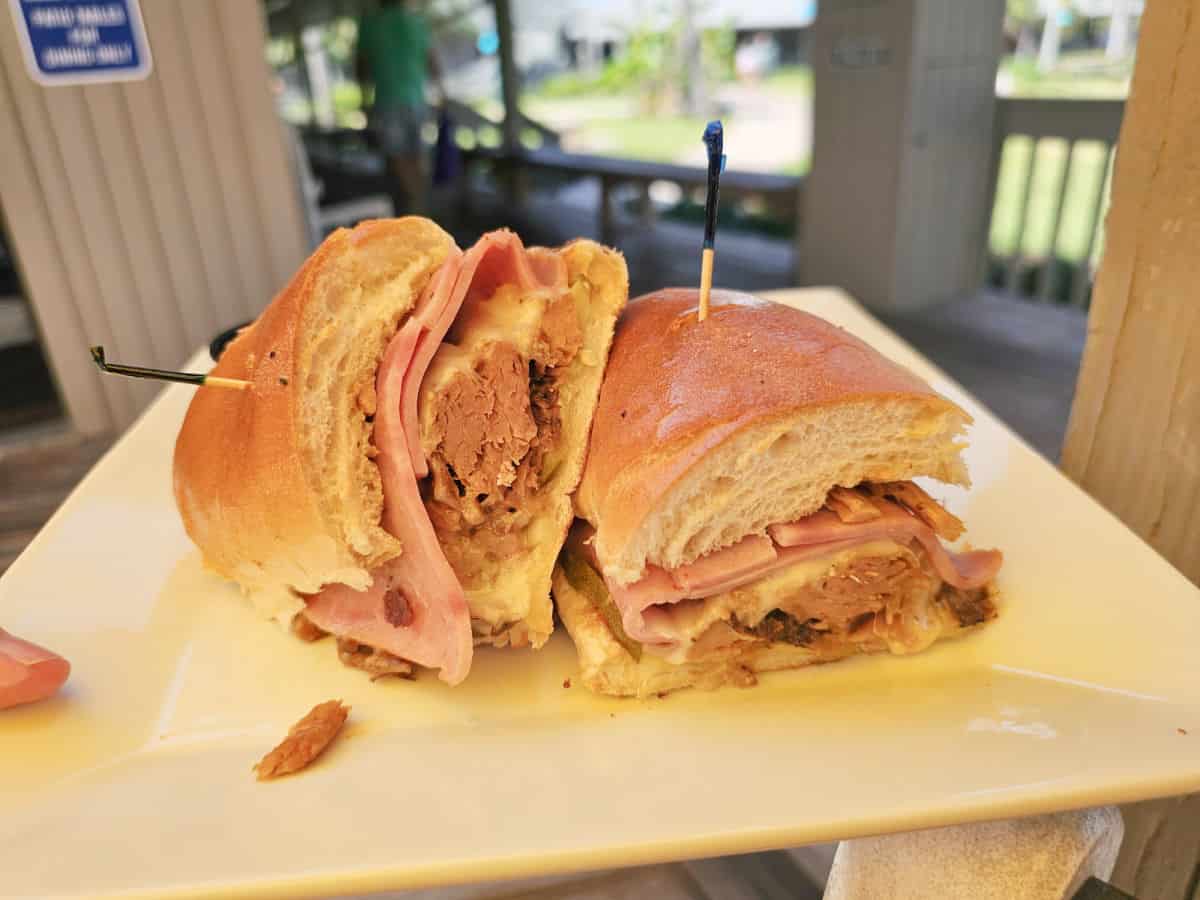 Cuban sandwich on a roll sitting on awhite plate