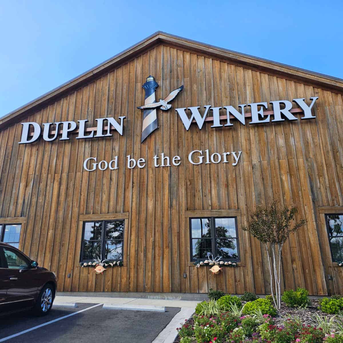 Duplin Winery sign with God be the Glory on a wooden building