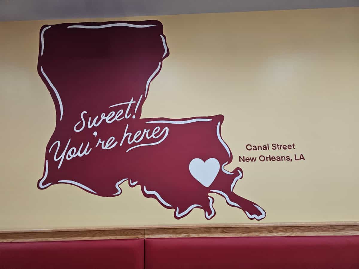 Mural with the state of Louisiana in red and "sweet you're here" canal street new orleans, la on it