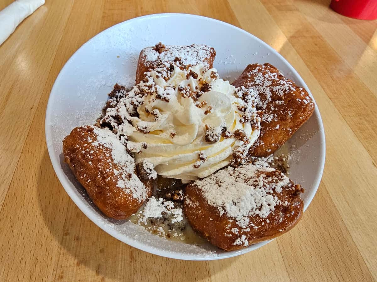 Beignets with whipped cream and powdered sugar