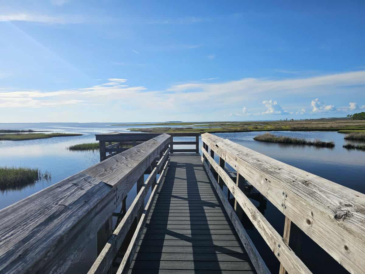 Boardwalk out to the water with clouds in the distance
