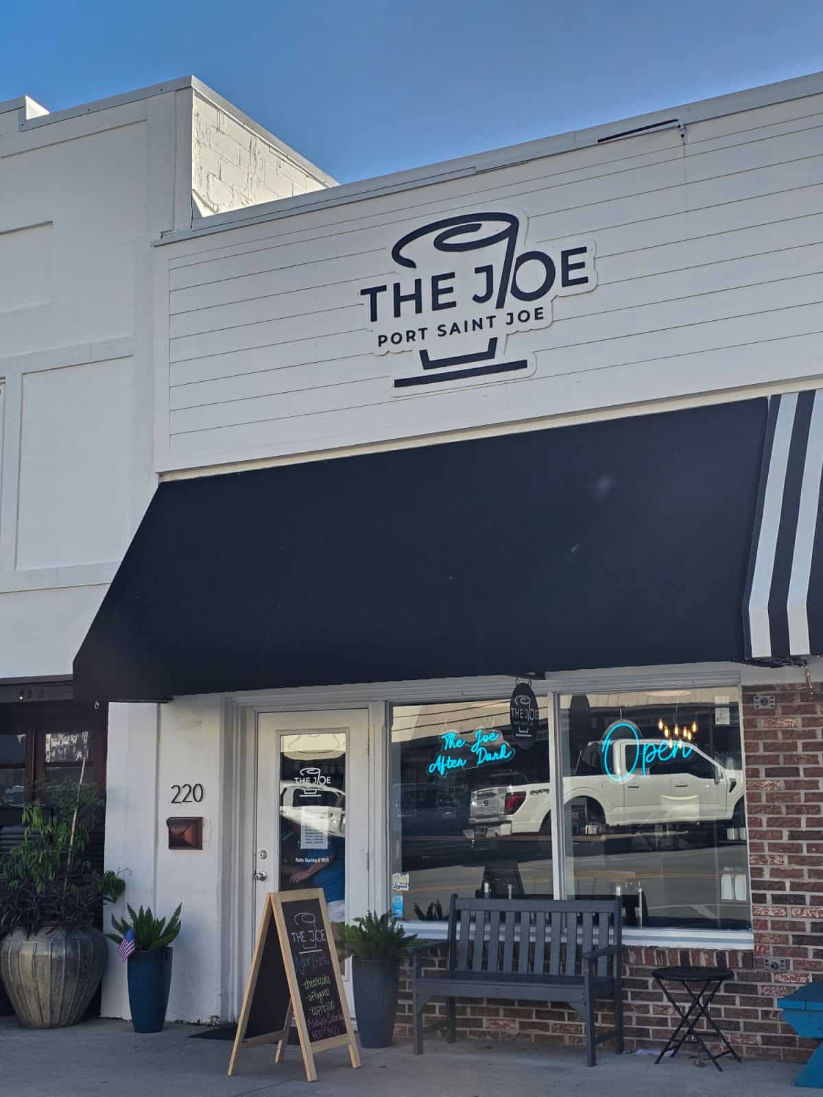 The Joe Port Saint Joe exterior with sign over the black awning