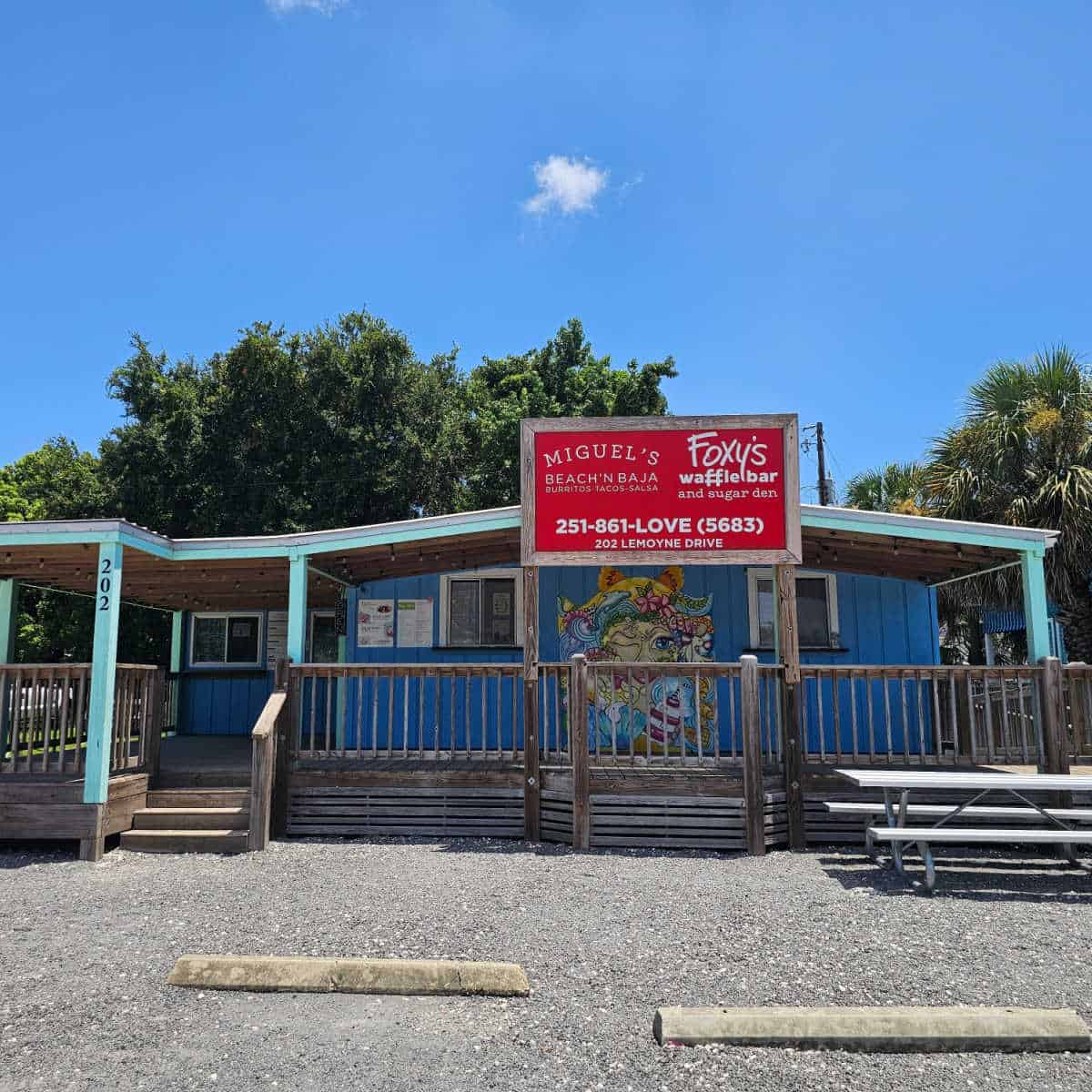 Foxy's Waffle Bar red sign in front of blue building