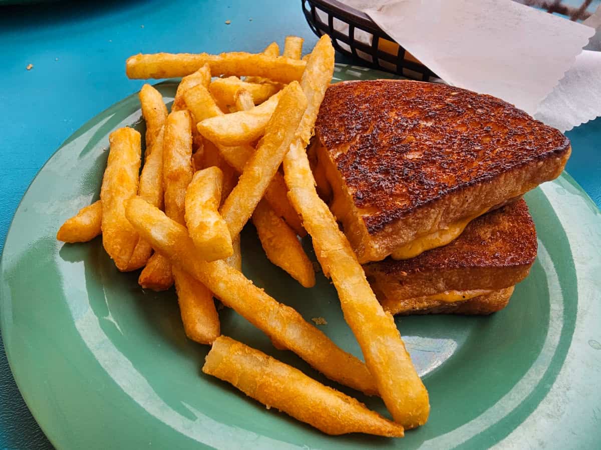 grilled cheese and fries on a green plate