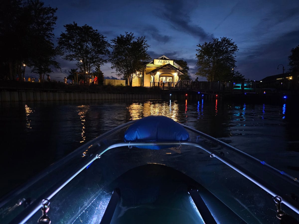 Clear kayak at night with Aura kayak office lit up