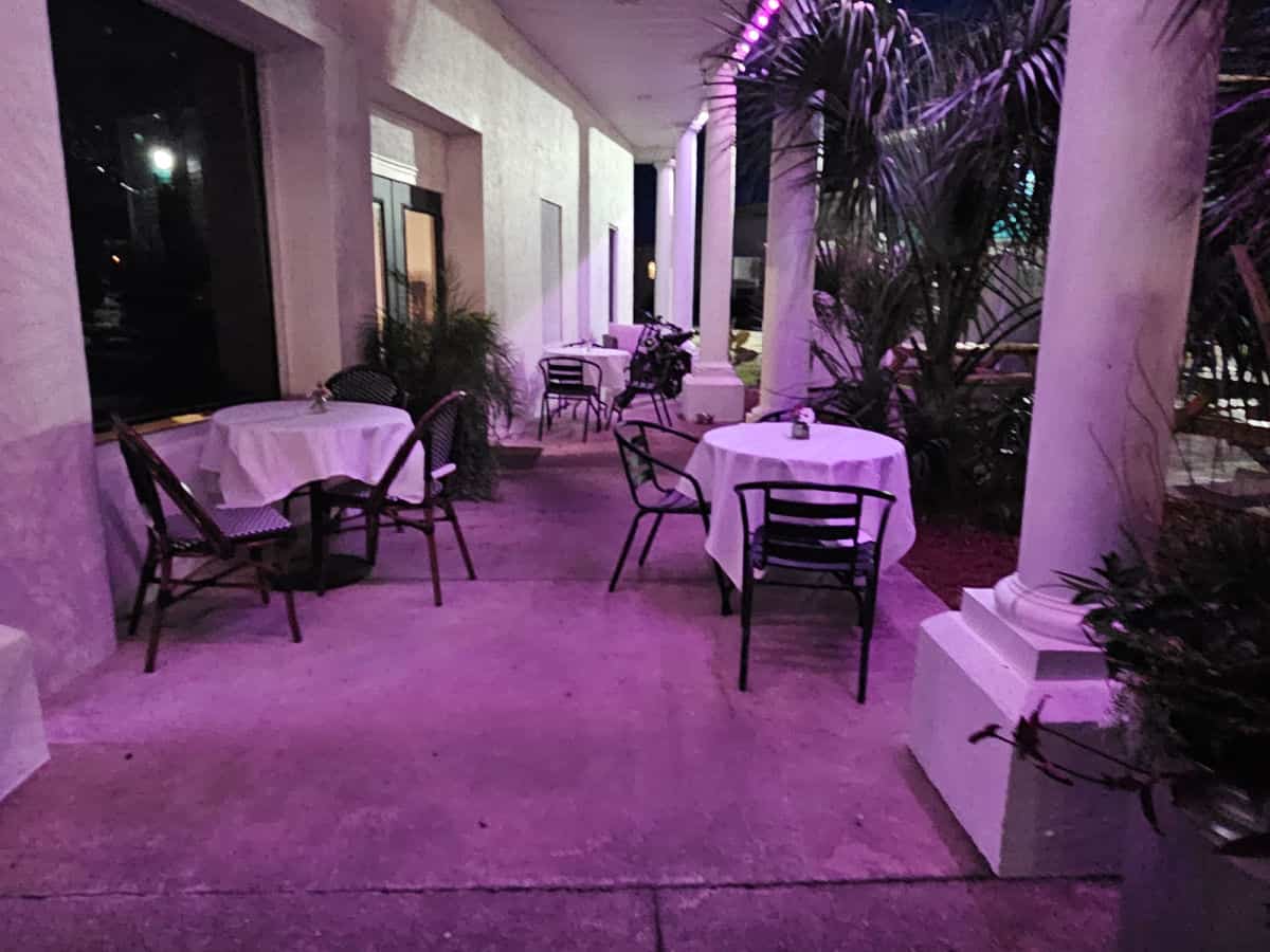 outdoor seating with tables and chairs and night lit up