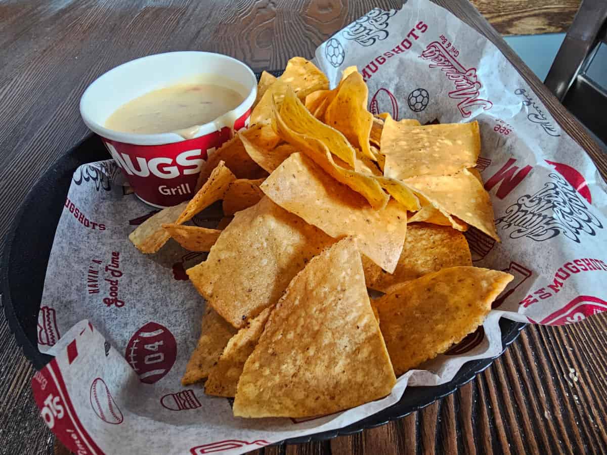 Chips and queso in a Mugshot paper lined basket