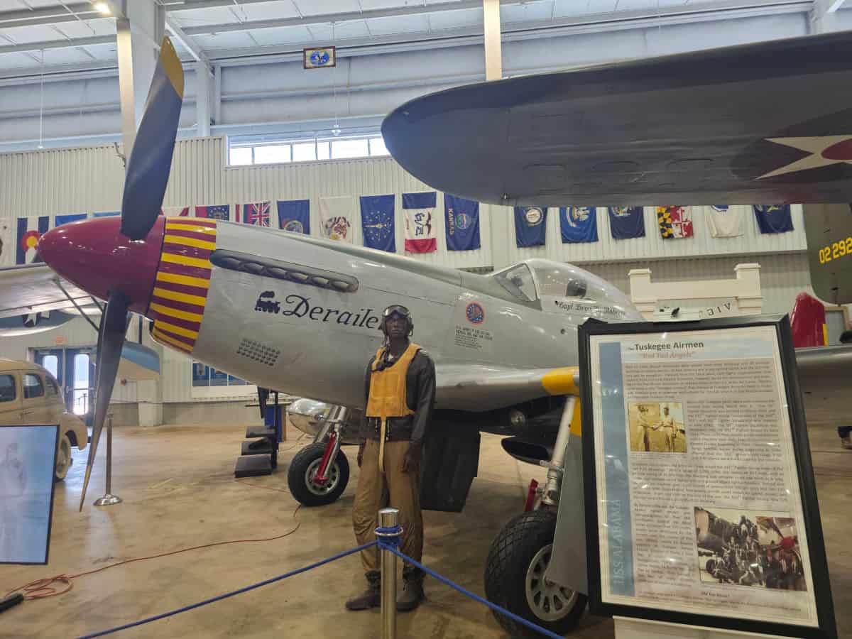 Tuskegee airmen model next to a plane and informational poster