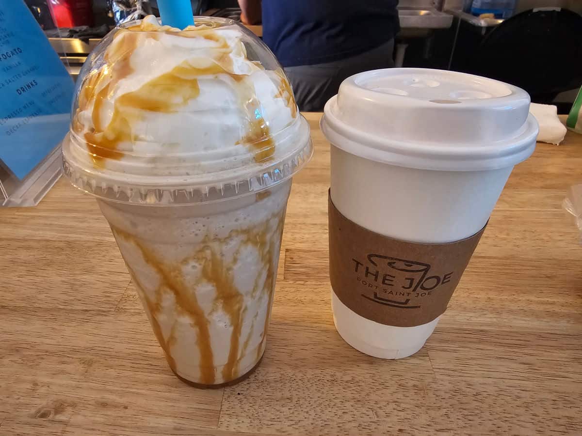 caramel frappuccino next to a cup of chai tea
