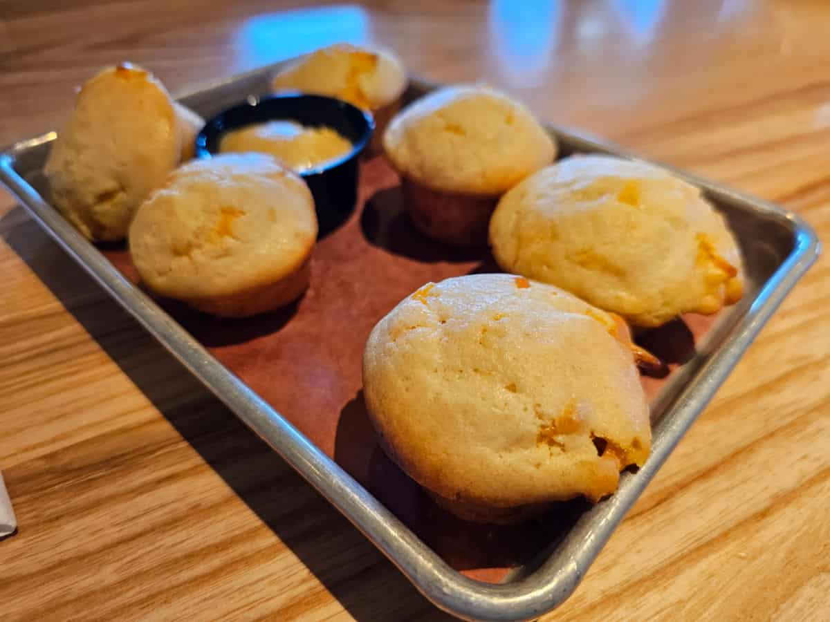 Tray of cheddar biscuits with a container of butter