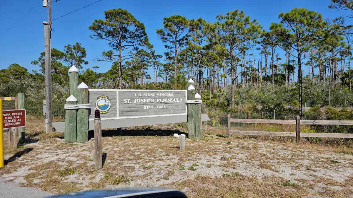 T H Stone Memorial St Joseph Peninsula State park sign with trees behind it