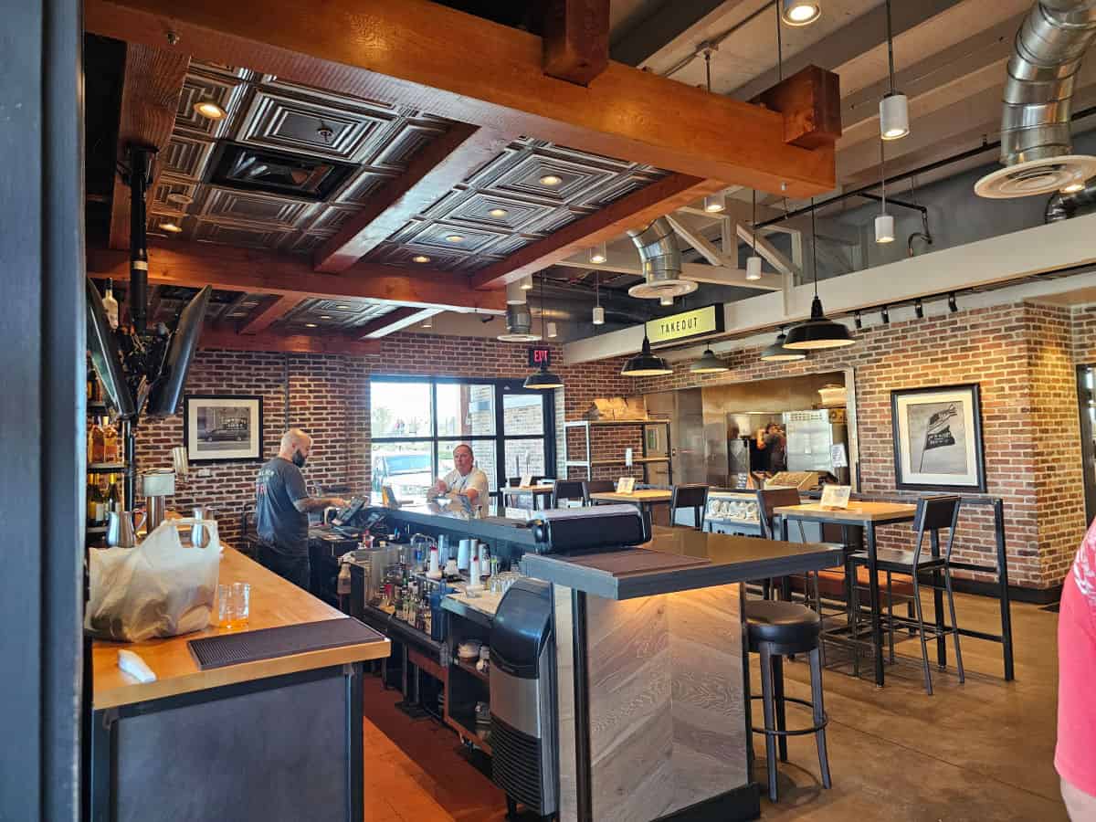 indoor bar with long counter, tall stools next to the takeout counter