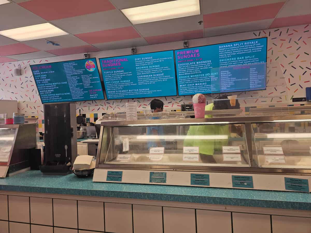 Inside Pink Pelican Ice Cream Bar with ice cream case and menus on the wall
